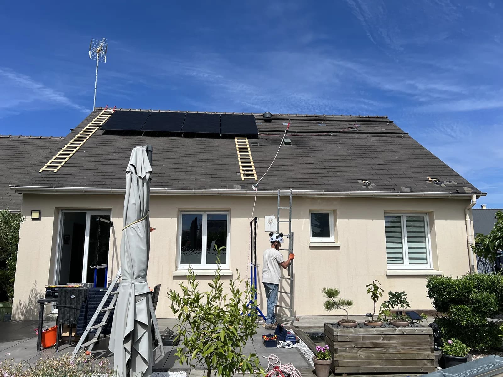 Pose de panneaux solaires sur le pan de toit d'une maison
